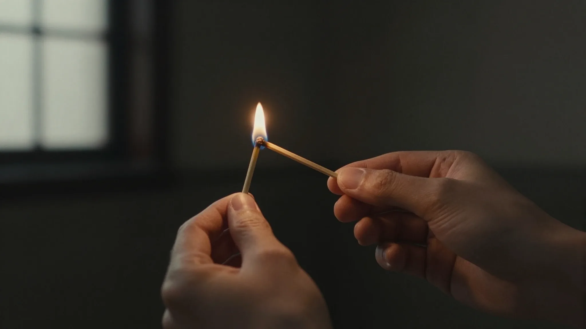 Hands lighting an incense stick with a match